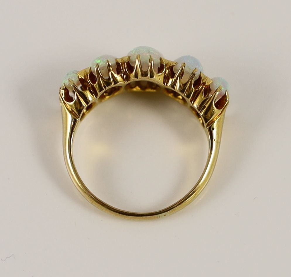 An Edwardian 18ct gold and five stone graduated white opal set half hoop ring
